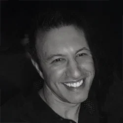 Black and white headshot of doctor with a bright smile